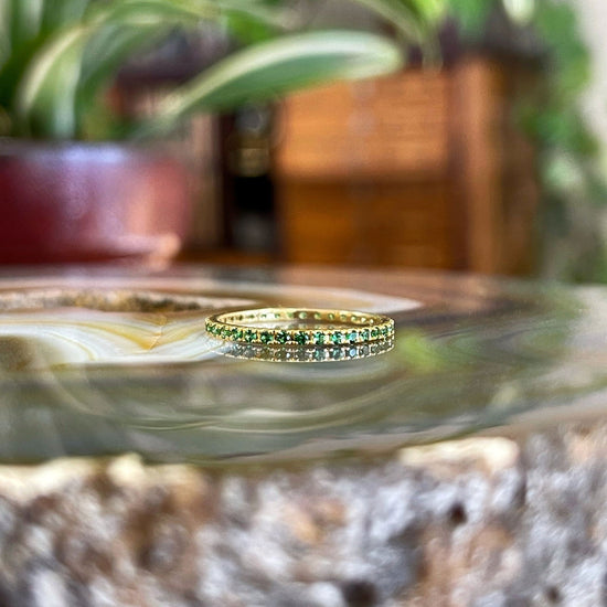 Photo of Gemstone Eternity Band in a decorative scene, designed by , available at Plumb Gold & Plumb Silver