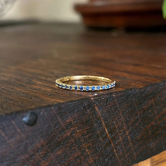 Photo of Gemstone Eternity Band in a decorative scene, designed by , available at Plumb Gold & Plumb Silver