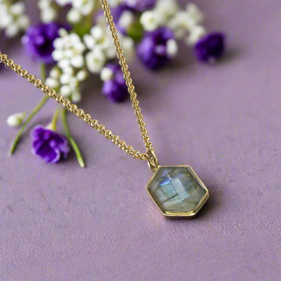 Photo of “Geo” Labradorite Pendant in a decorative scene, designed by , available at Plumb Gold & Plumb Silver