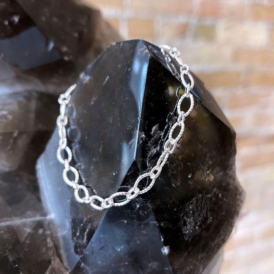 Photo of Gnarled Link Bracelet in a decorative scene, designed by , available at Plumb Gold & Plumb Silver