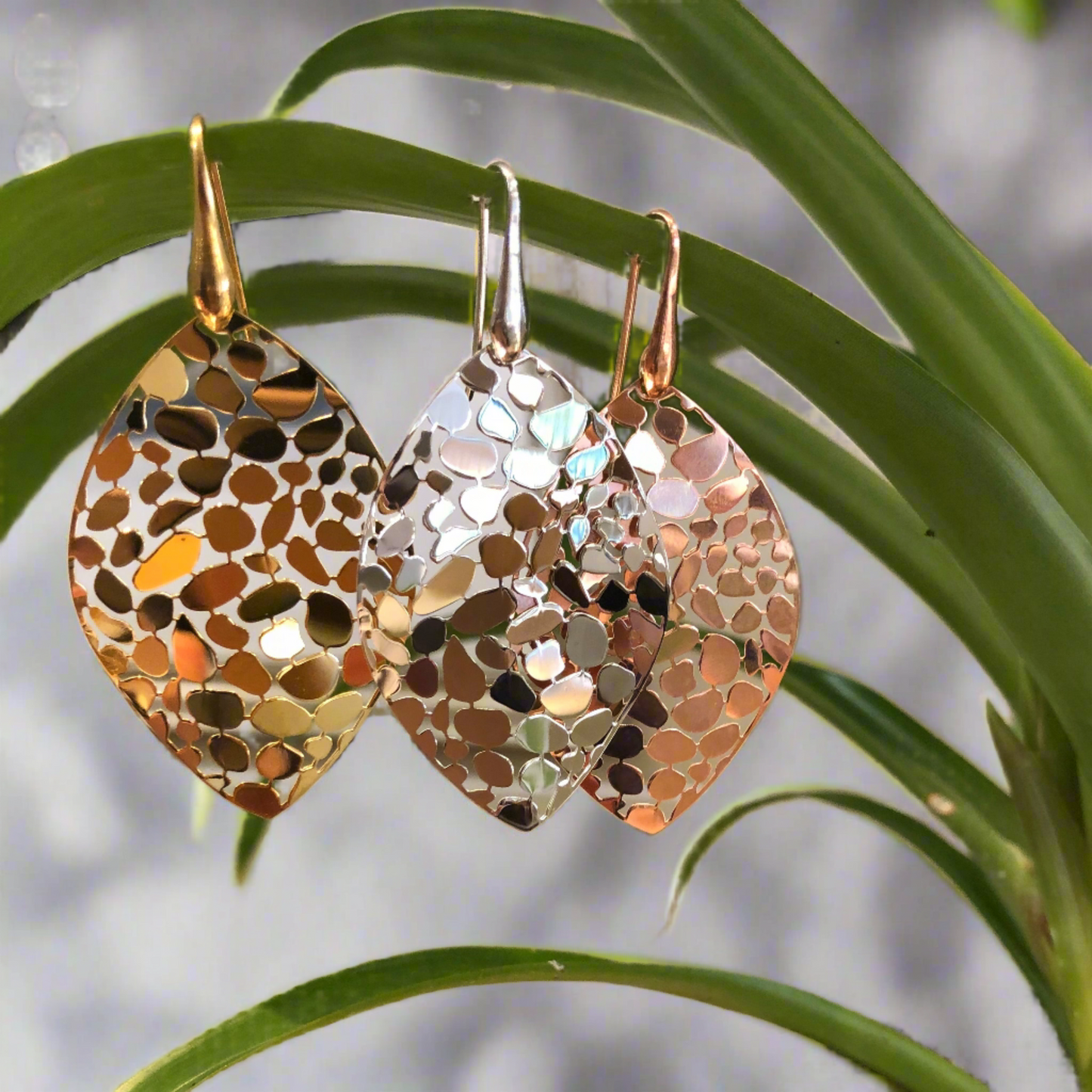 Photo of Gold Plated Mosaic Leaf Dangle Earrings in a decorative scene, designed by , available at Plumb Gold & Plumb Silver