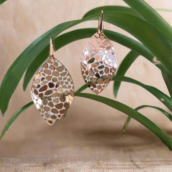 Photo of Gold Plated Mosaic Leaf Dangle Earrings in a decorative scene, designed by , available at Plumb Gold & Plumb Silver