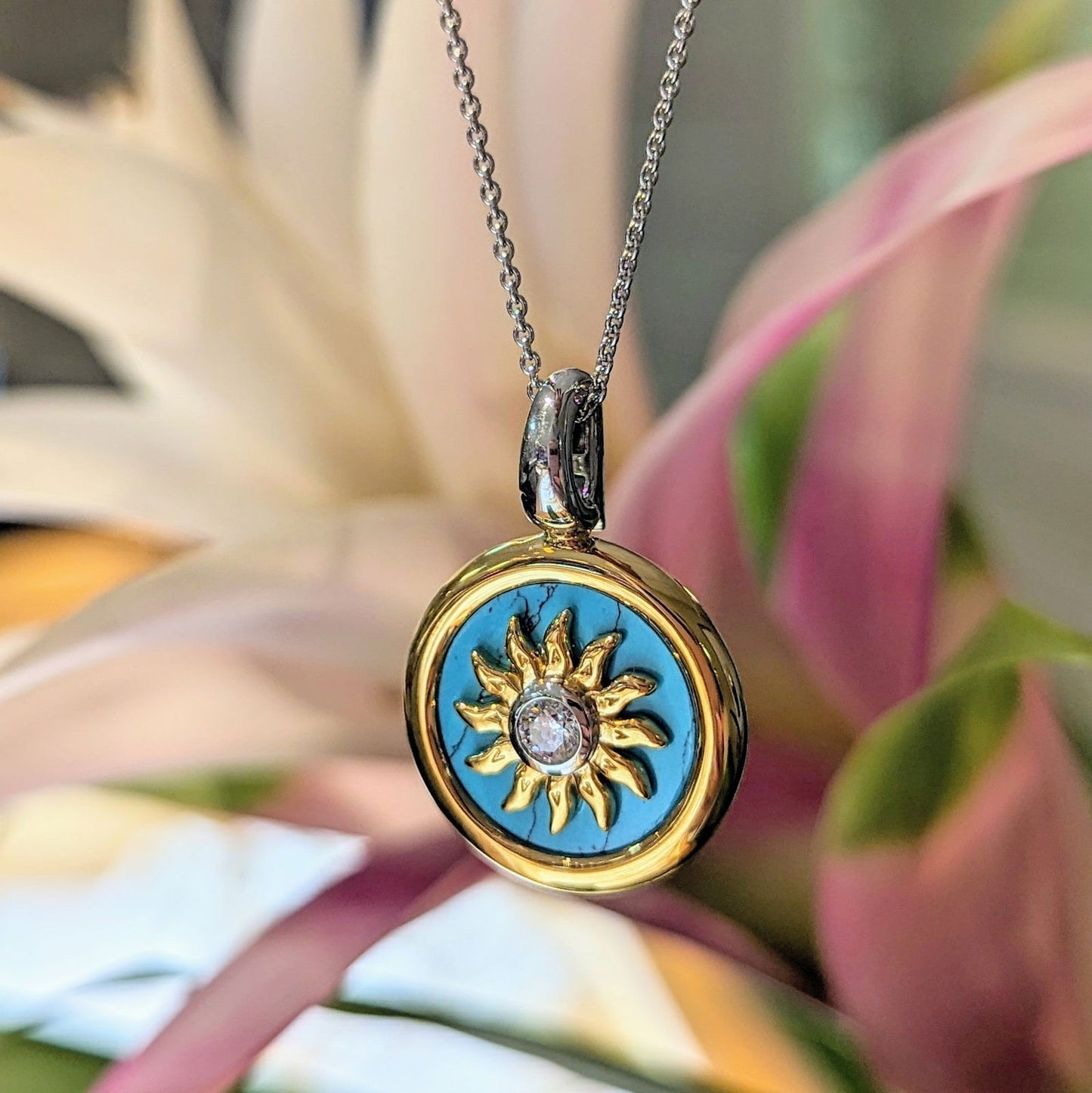 Photo of Gold plated sunburst turquoise necklace in a decorative scene, designed by , available at Plumb Gold & Plumb Silver