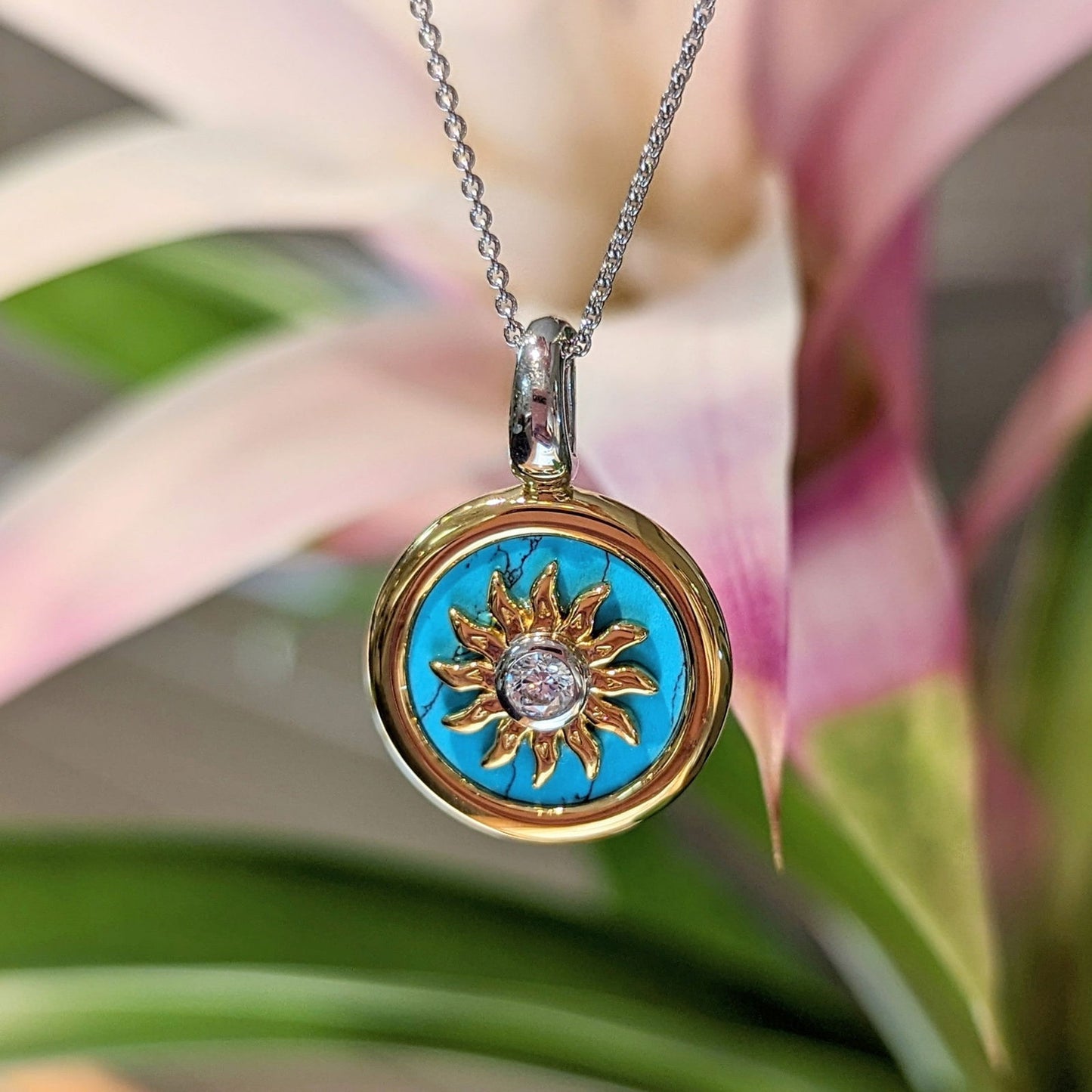 Photo of Gold plated sunburst turquoise necklace in a decorative scene, designed by , available at Plumb Gold & Plumb Silver