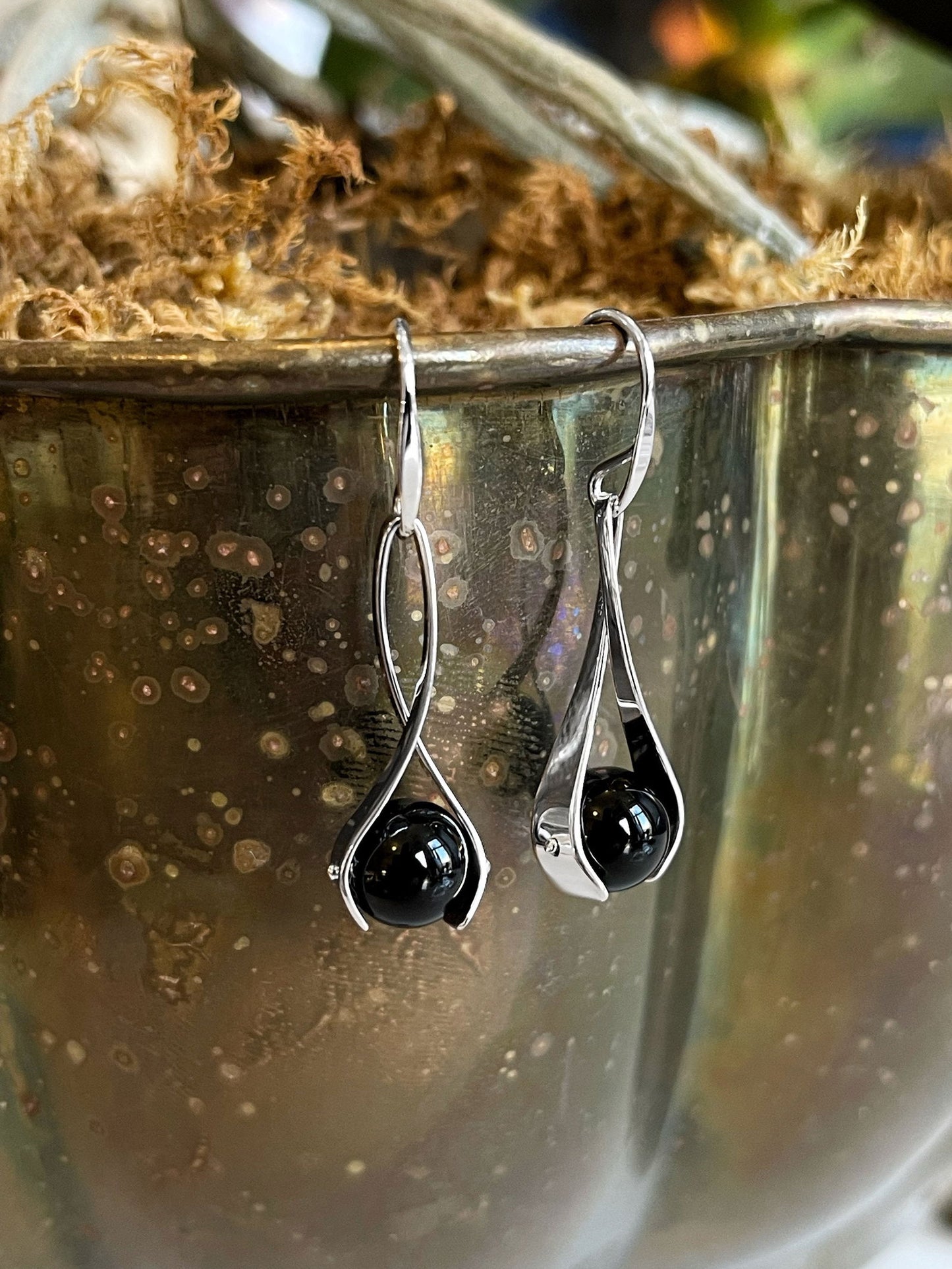 Photo of "Grace" Earrings in a decorative scene, designed by , available at Plumb Gold & Plumb Silver