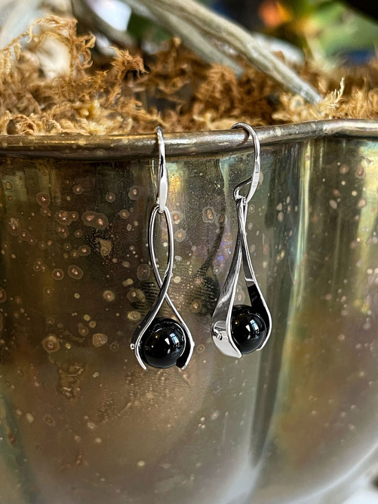 Photo of "Grace" Earrings in a decorative scene, designed by , available at Plumb Gold & Plumb Silver