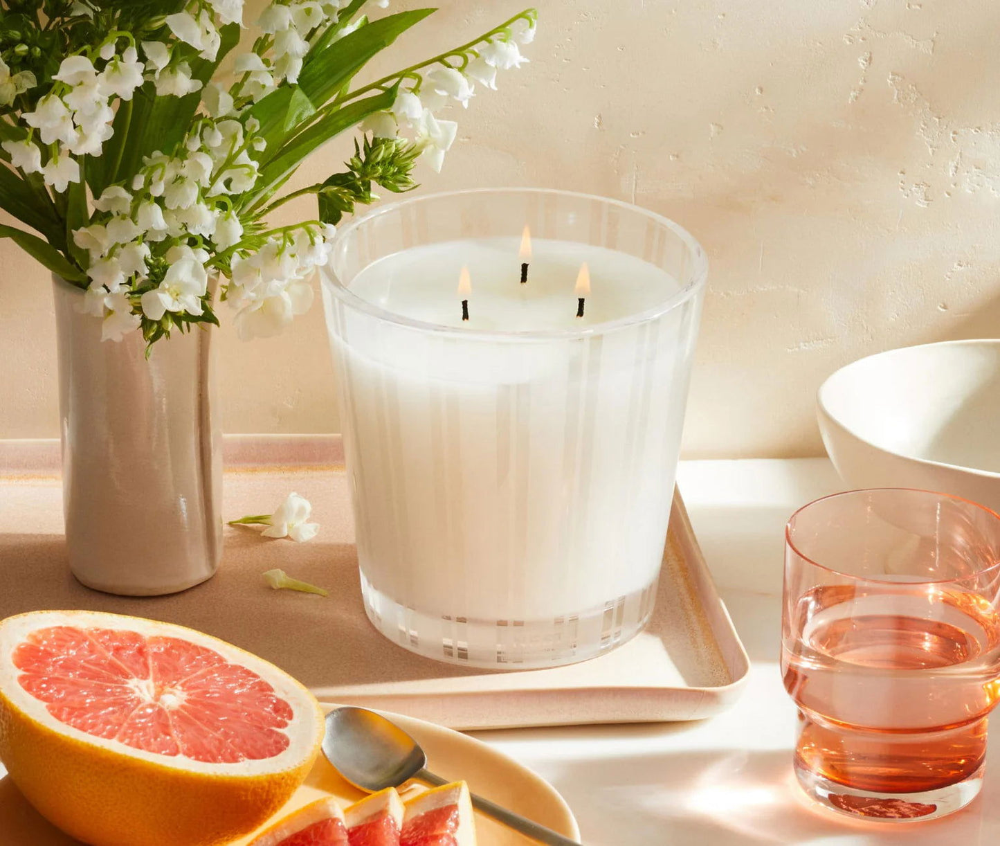 Photo of Grapefruit Candle in a decorative scene, designed by , available at Plumb Gold & Plumb Silver