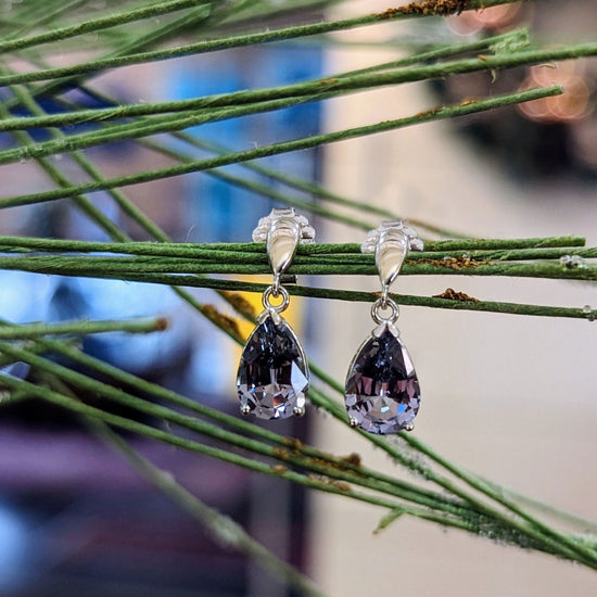 Photo of Grey Spinel Dangle Earrings in a decorative scene, designed by , available at Plumb Gold & Plumb Silver