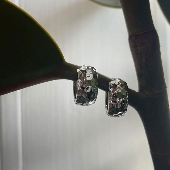 Photo of Hammered Hinged Hoop Earring in a decorative scene, designed by , available at Plumb Gold & Plumb Silver