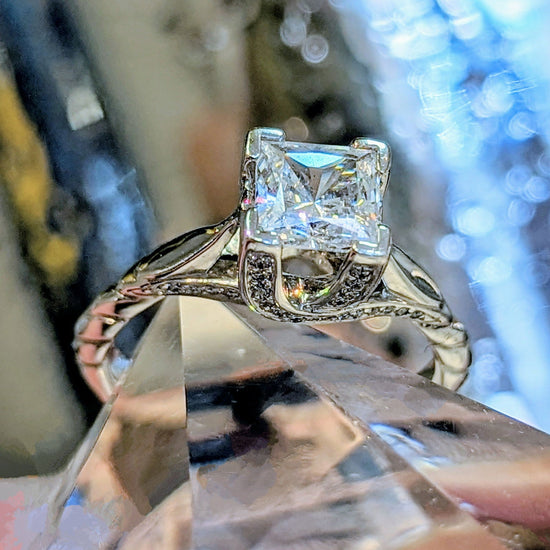 Photo of "Harris" Ring in a decorative scene, designed by , available at Plumb Gold & Plumb Silver