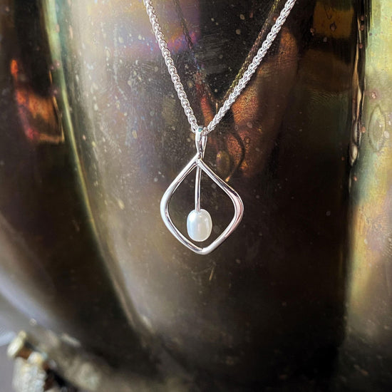Photo of "Highlight" Necklace in a decorative scene, designed by , available at Plumb Gold & Plumb Silver