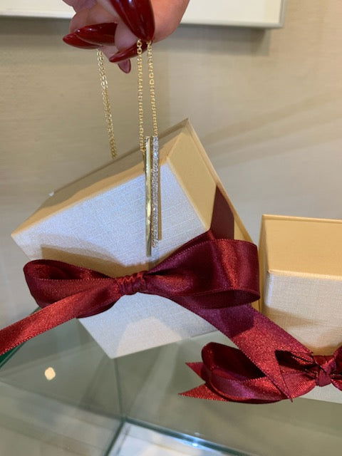 Photo of I.Reiss 14K Yellow Gold Double Bar Diamond Pendant 17in chain in a decorative scene, designed by , available at Plumb Gold & Plumb Silver