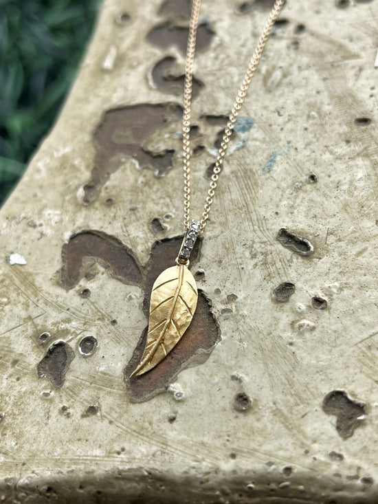 Photo of I.Reiss Diamond Leaf Necklace in a decorative scene, designed by , available at Plumb Gold & Plumb Silver