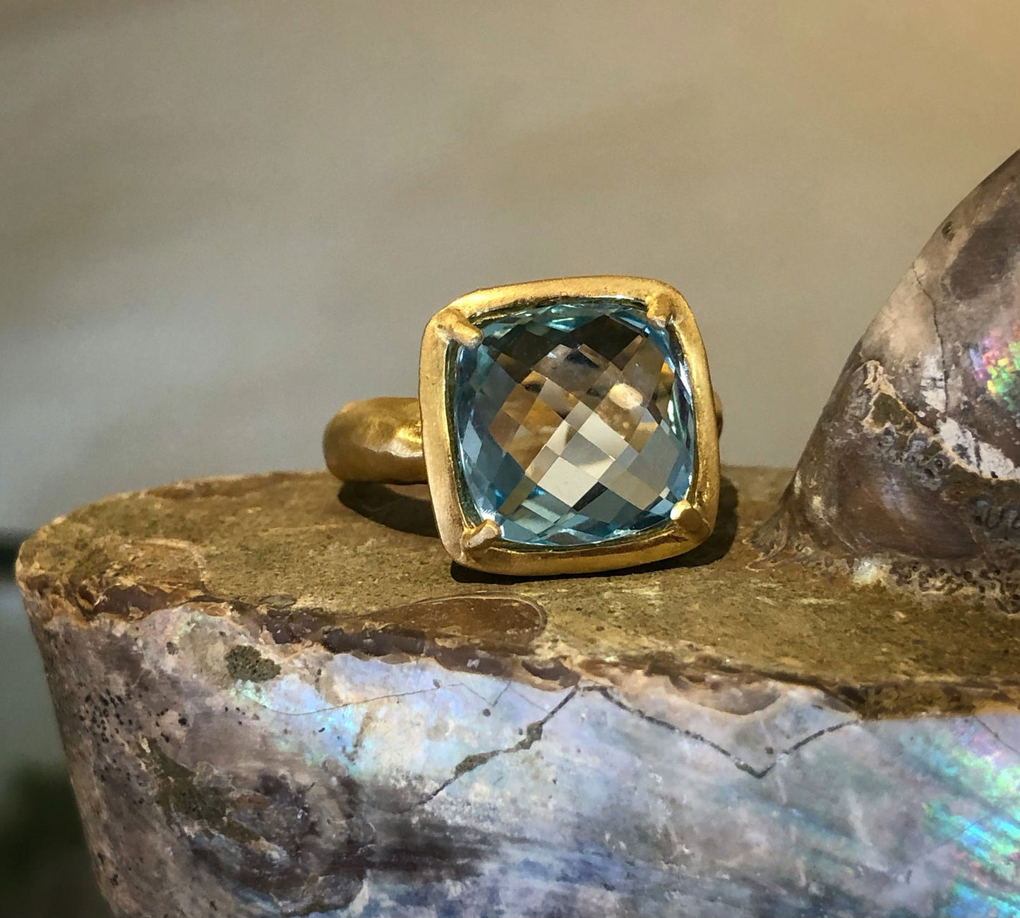 Photo of I. Reiss Blue Topaz Checkerboard Gold Gallery Ring in a decorative scene, designed by , available at Plumb Gold & Plumb Silver