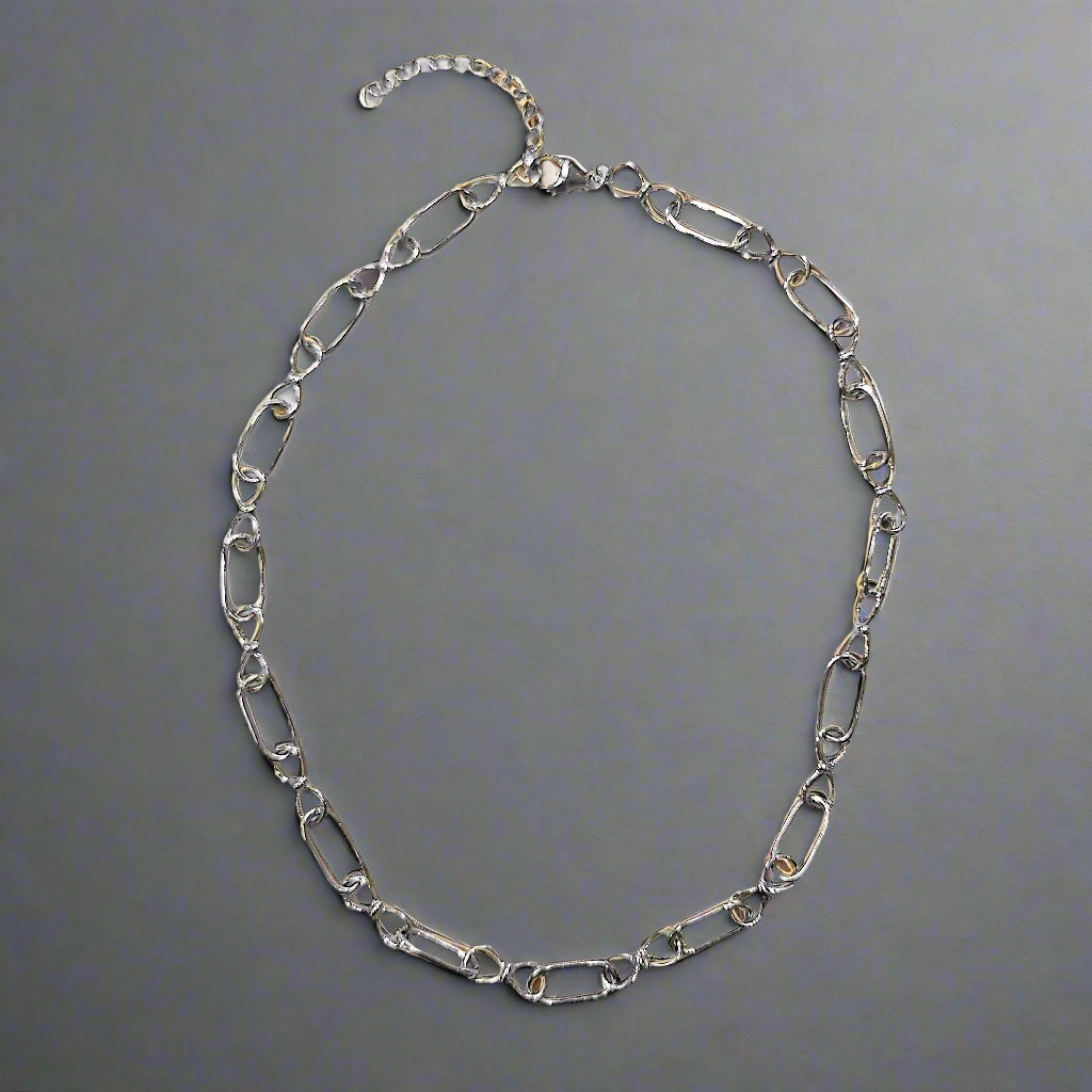Photo of Infinity Link Chain in a decorative scene, designed by , available at Plumb Gold & Plumb Silver