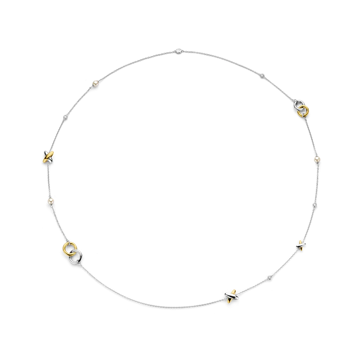 Photo of Intertwined Circle & Cross Station Necklace in a decorative scene, designed by -, available at Plumb Gold & Plumb Silver