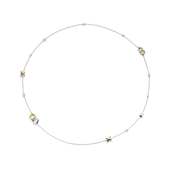 Photo of Intertwined Circle & Cross Station Necklace in a decorative scene, designed by -, available at Plumb Gold & Plumb Silver