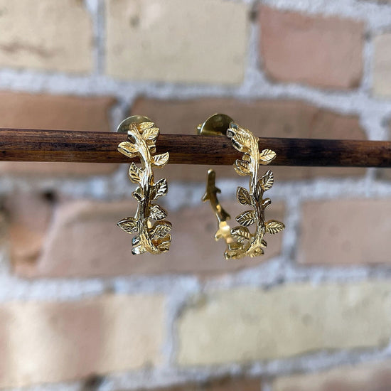 Photo of “Ivy” Hoops in a decorative scene, designed by , available at Plumb Gold & Plumb Silver