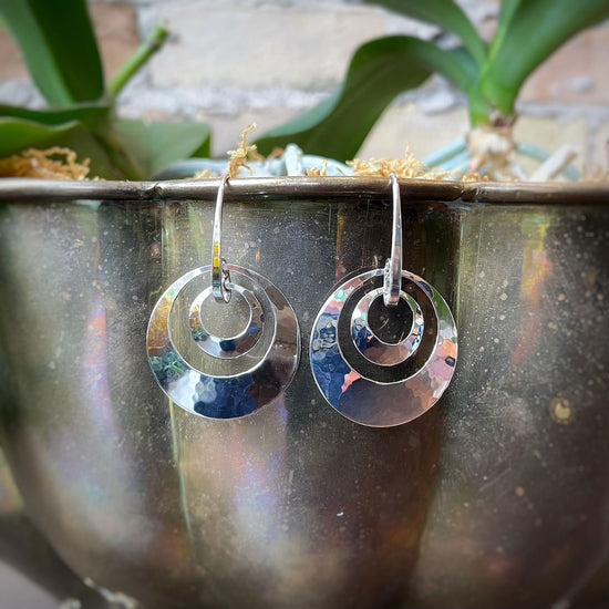 Photo of "Jaunty" Dangle Earrings in a decorative scene, designed by , available at Plumb Gold & Plumb Silver