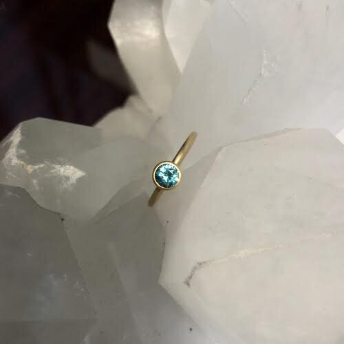 Photo of Kim Collins Blue Zircon Yum Drop in a decorative scene, designed by , available at Plumb Gold & Plumb Silver
