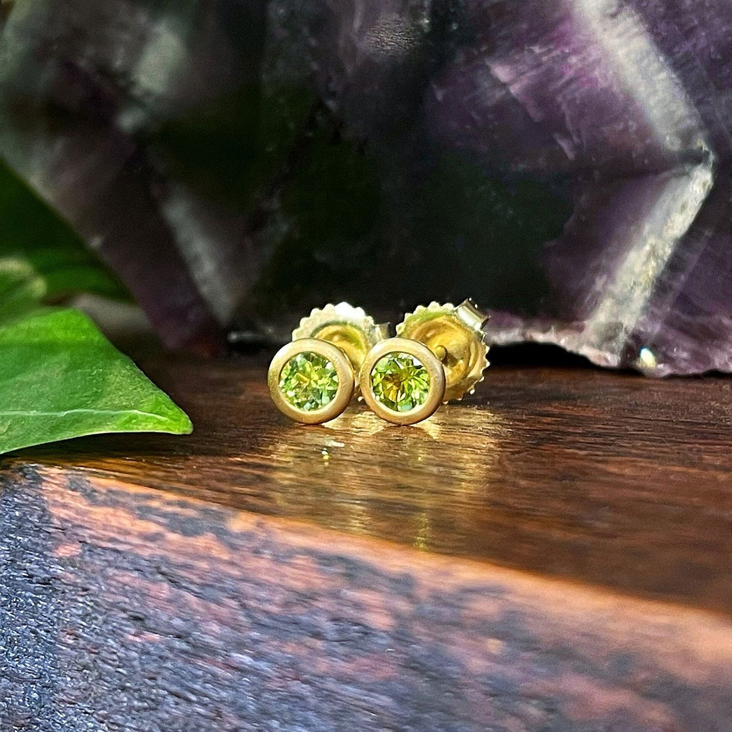 Photo of Kim Collins Peridot Studs in a decorative scene, designed by , available at Plumb Gold & Plumb Silver