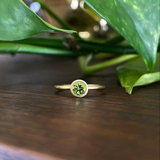 Photo of Kim Collins Peridot Yum Drop in a decorative scene, designed by , available at Plumb Gold & Plumb Silver