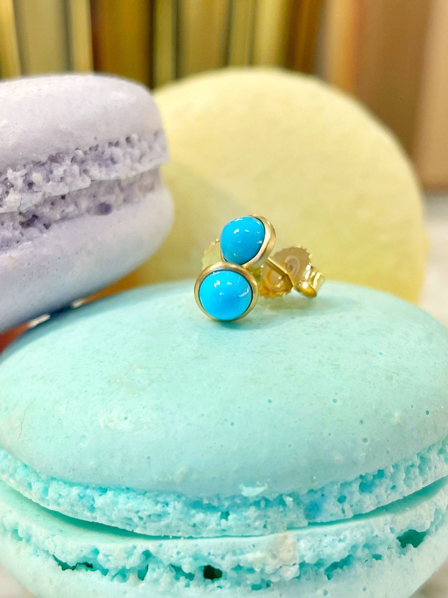 Photo of Kim Collins Turquoise Bezel Studs in a decorative scene, designed by , available at Plumb Gold & Plumb Silver