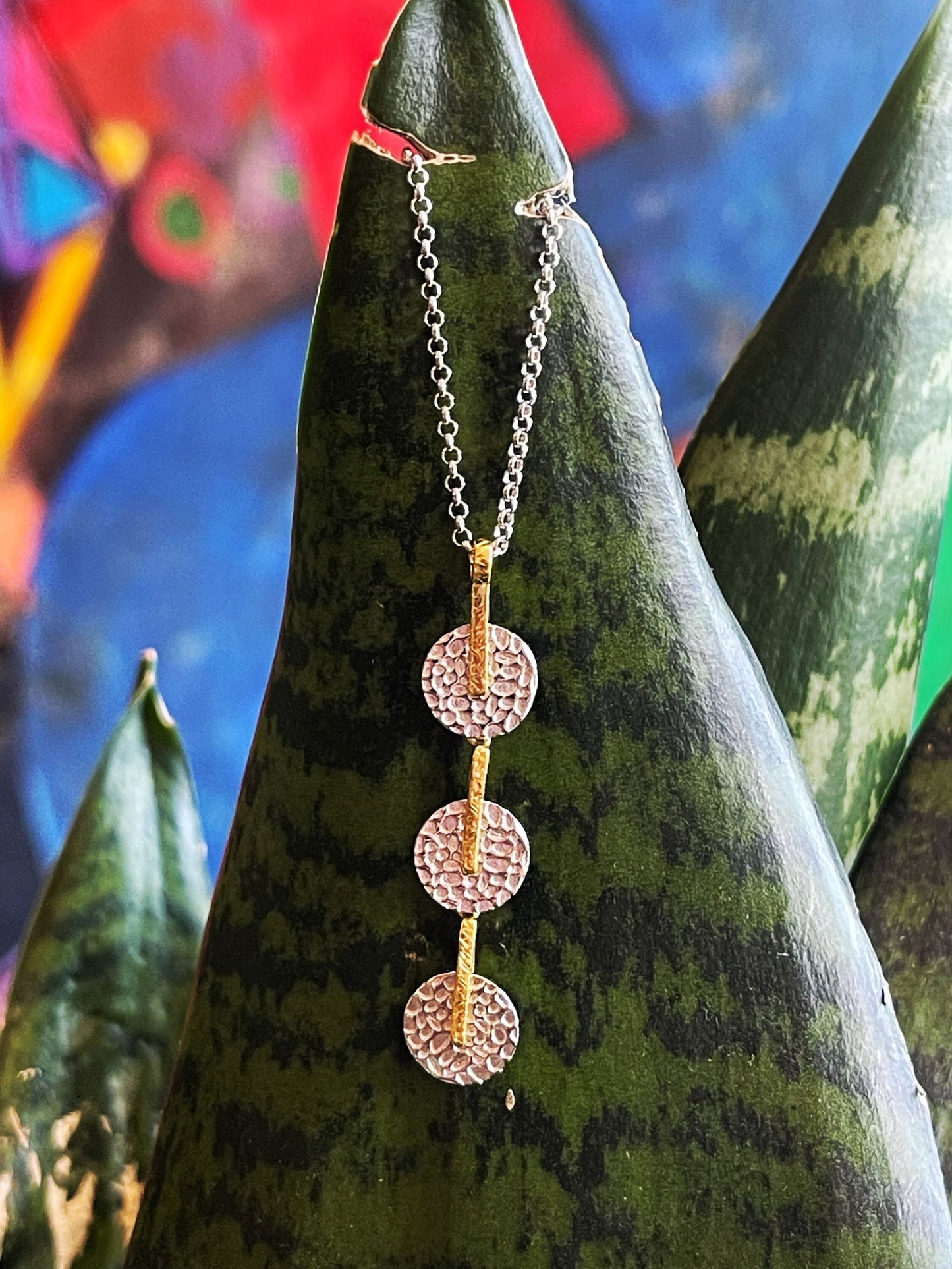 Photo of "Kymbal" Segmented Pendant in a decorative scene, designed by , available at Plumb Gold & Plumb Silver