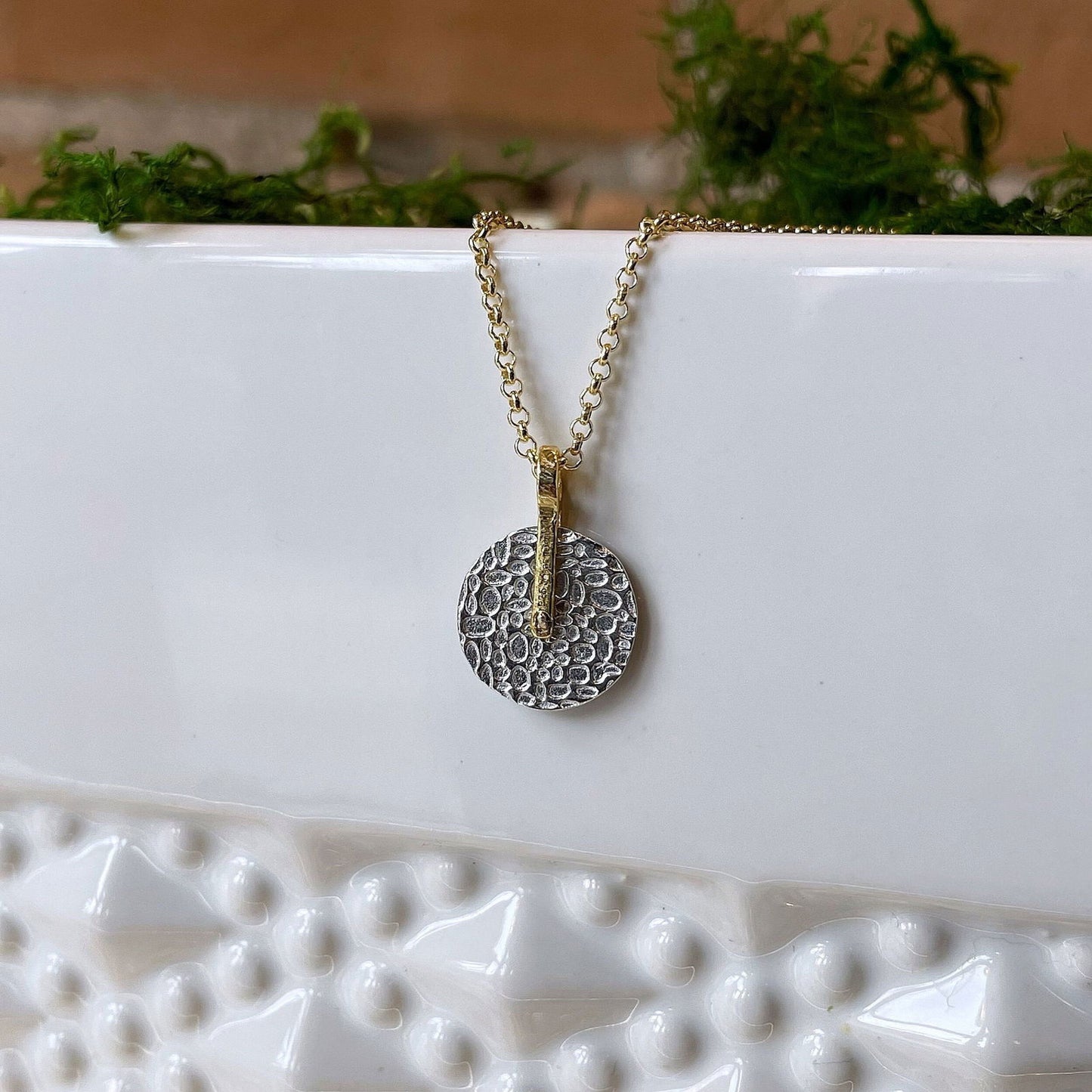 Photo of "Kymbal" pendant in a decorative scene, designed by -, available at Plumb Gold & Plumb Silver