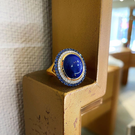 Photo of Lapis  Cabochon Halo Ring in a decorative scene, designed by , available at Plumb Gold & Plumb Silver