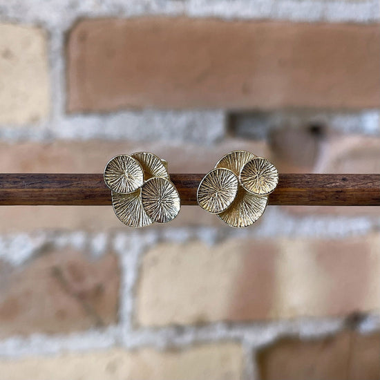 Photo of “Lilly” Studs in a decorative scene, designed by , available at Plumb Gold & Plumb Silver