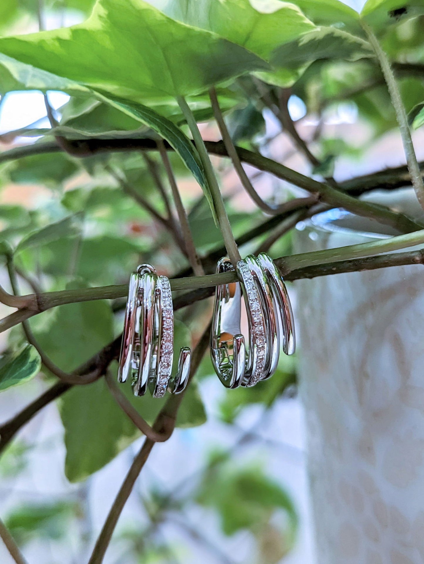 Photo of Line Diamond Accented Huggie Earrings in a decorative scene, designed by , available at Plumb Gold & Plumb Silver