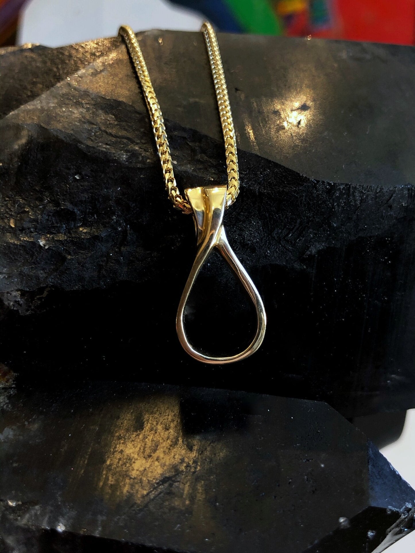 Photo of Loop Pendant in a decorative scene, designed by , available at Plumb Gold & Plumb Silver