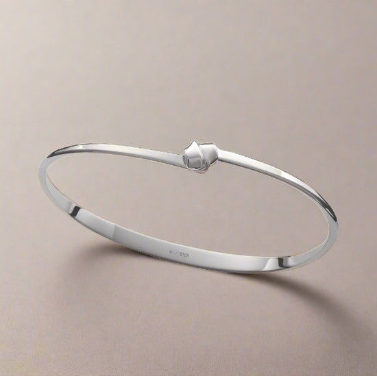 Photo of "Love Knot" Bracelet in a decorative scene, designed by , available at Plumb Gold & Plumb Silver