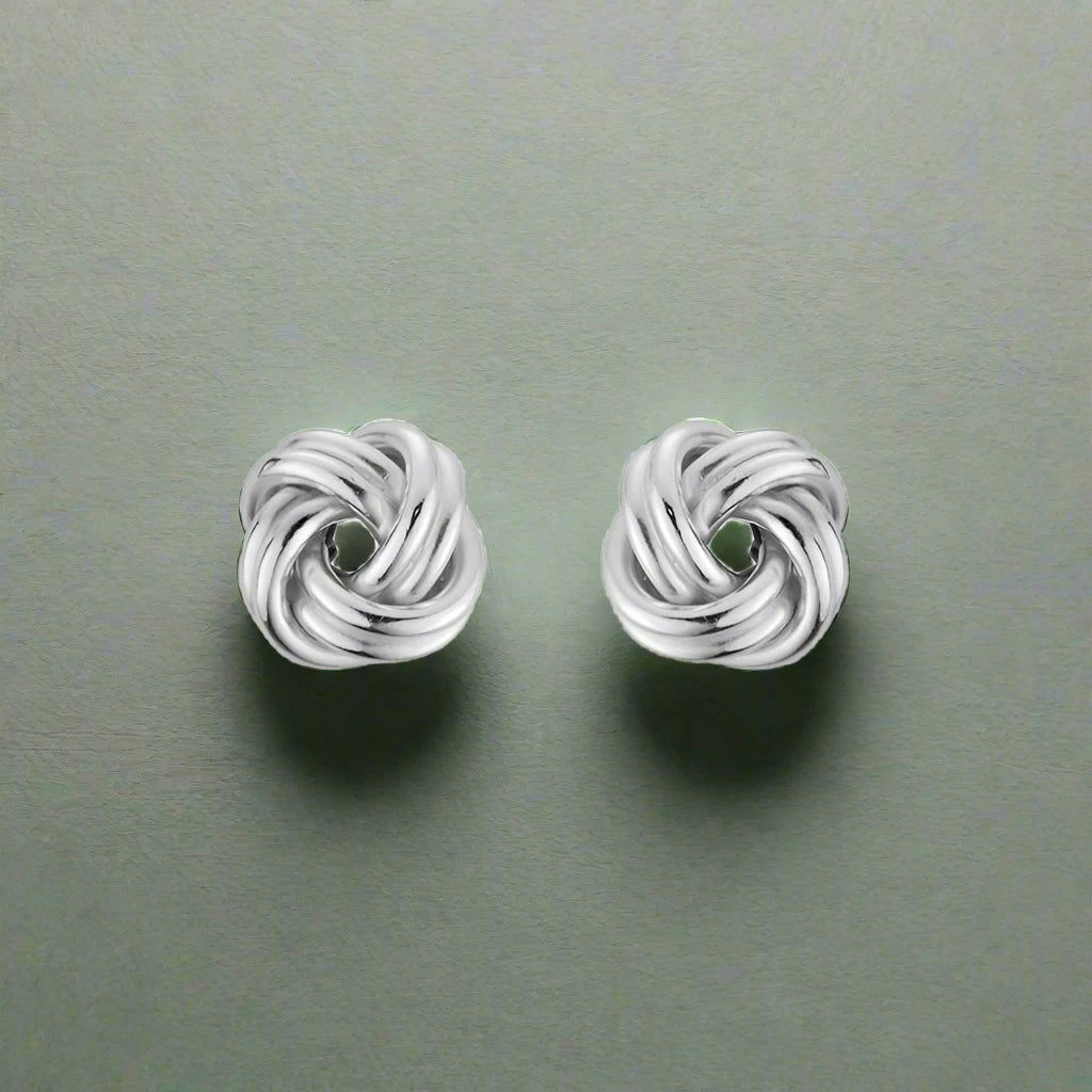 Photo of Love Knot Earrings in a decorative scene, designed by , available at Plumb Gold & Plumb Silver