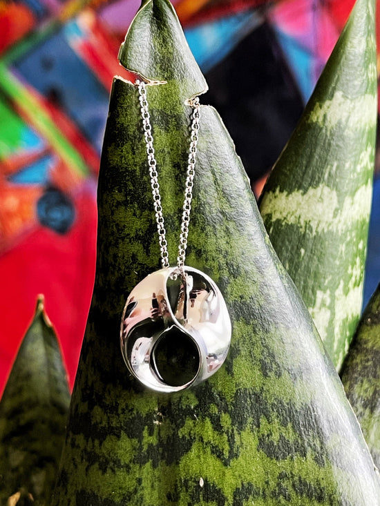 Photo of "Love" Pendant in a decorative scene, designed by , available at Plumb Gold & Plumb Silver