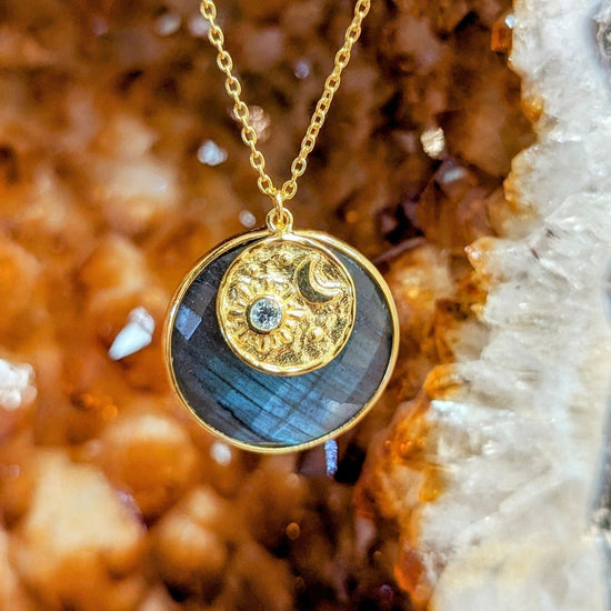 Photo of "Luna" Celestial Labradorite Blue Topaz Necklace in a decorative scene, designed by , available at Plumb Gold & Plumb Silver