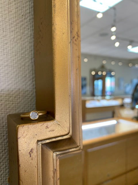 Photo of Matte Pavé Bezel Ring in a decorative scene, designed by , available at Plumb Gold & Plumb Silver