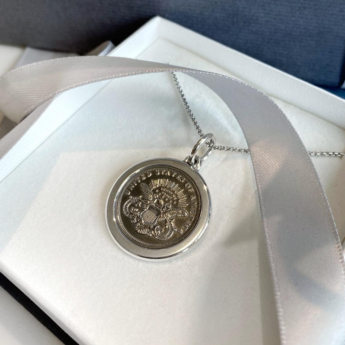 Photo of "Military" Pendant in a decorative scene, designed by , available at Plumb Gold & Plumb Silver