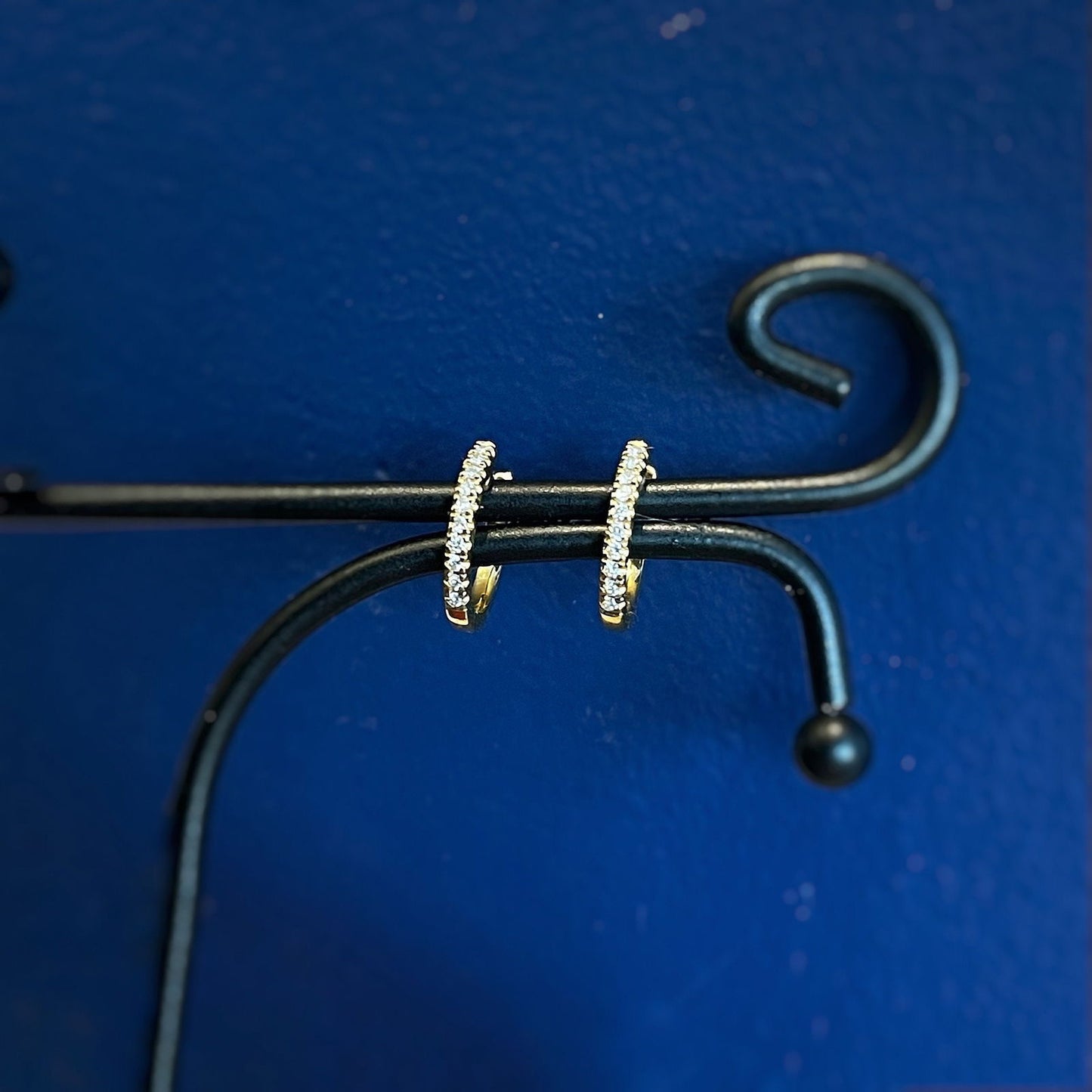 Photo of Mini Diamond Hoops in a decorative scene, designed by , available at Plumb Gold & Plumb Silver