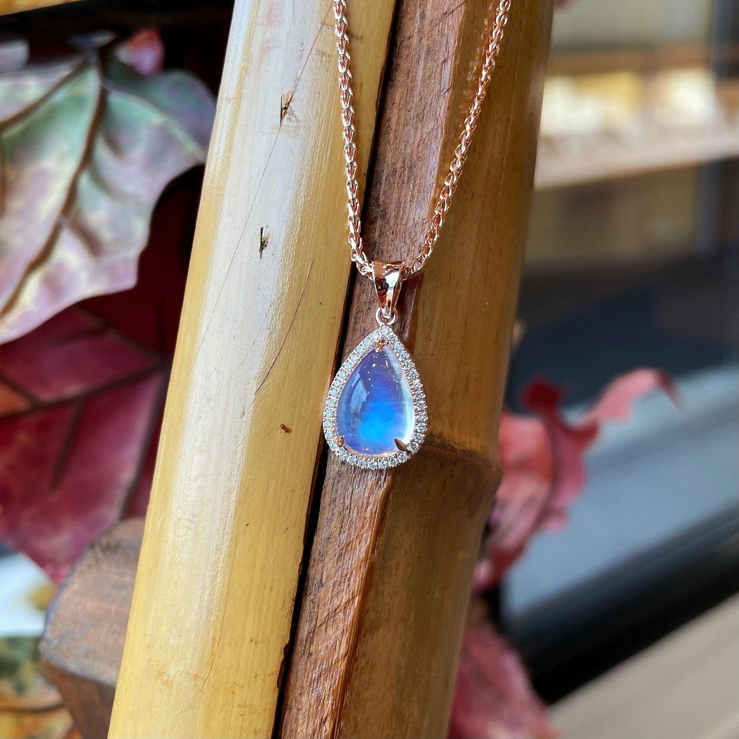 Photo of Moonstone Diamond Pendant in a decorative scene, designed by , available at Plumb Gold & Plumb Silver