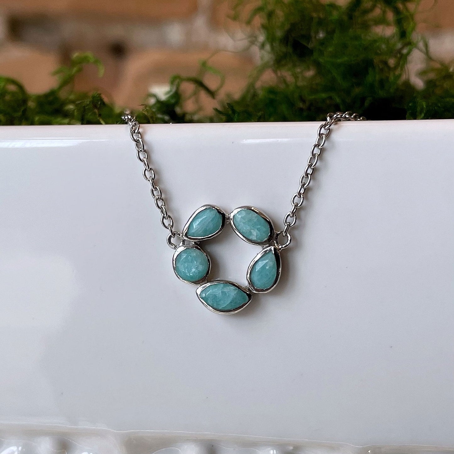 Photo of “Morning” Amazonite Necklace in a decorative scene, designed by , available at Plumb Gold & Plumb Silver
