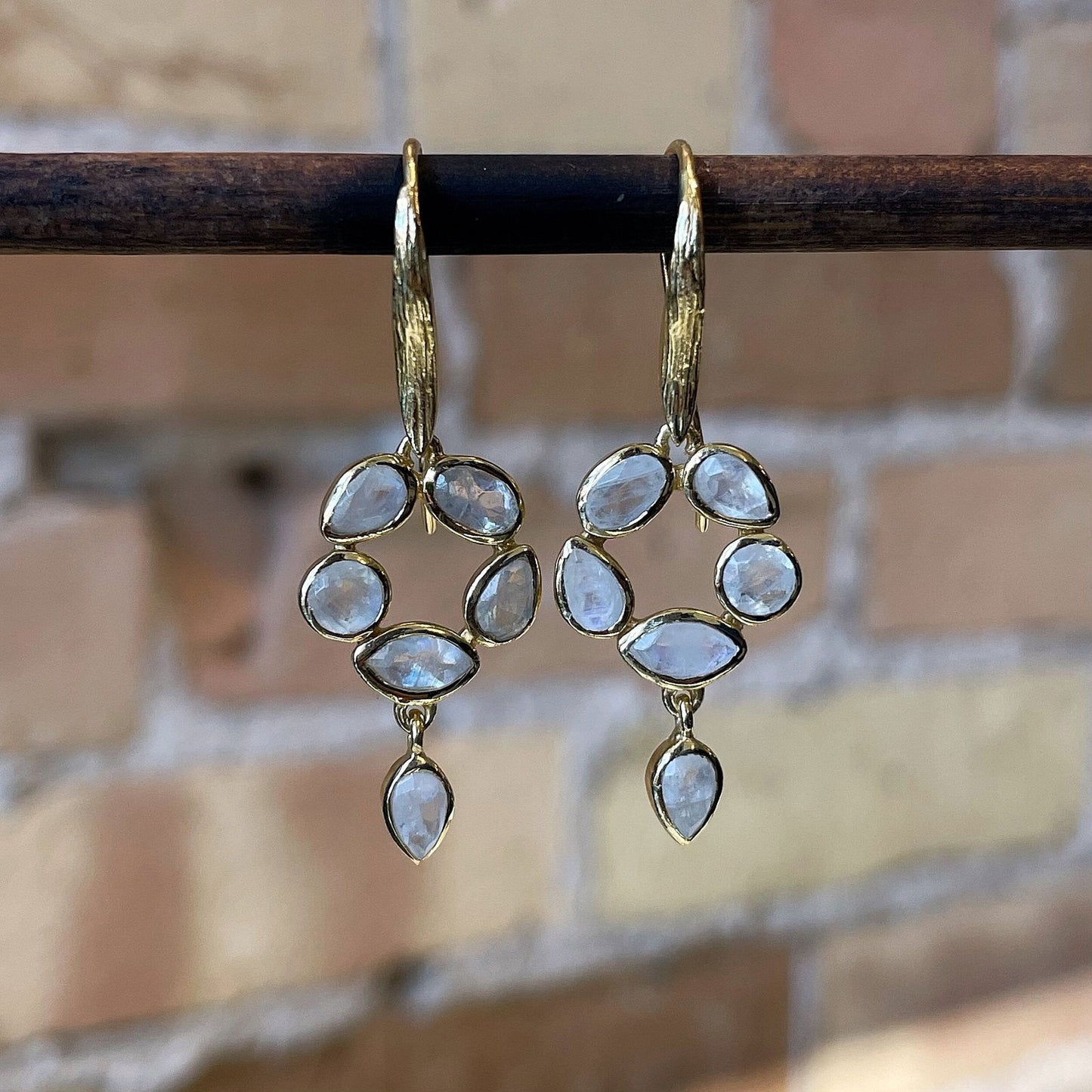 Photo of “Morning” Moonstone Dangles in a decorative scene, designed by , available at Plumb Gold & Plumb Silver
