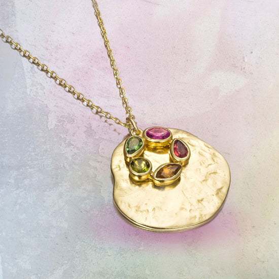 Photo of "Morning" Tourmaline Necklace in a decorative scene, designed by , available at Plumb Gold & Plumb Silver