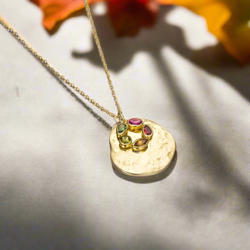 Photo of "Morning" Tourmaline Necklace in a decorative scene, designed by , available at Plumb Gold & Plumb Silver
