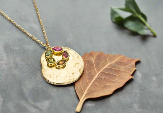 Photo of "Morning" Tourmaline Necklace in a decorative scene, designed by , available at Plumb Gold & Plumb Silver