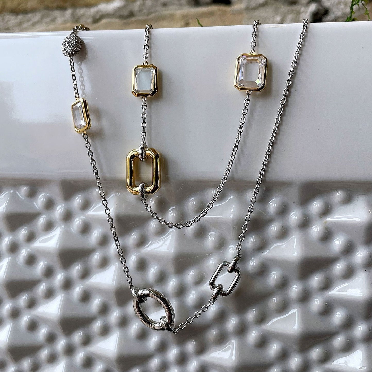 Photo of Multi-Shape Station Necklace in a decorative scene, designed by , available at Plumb Gold & Plumb Silver
