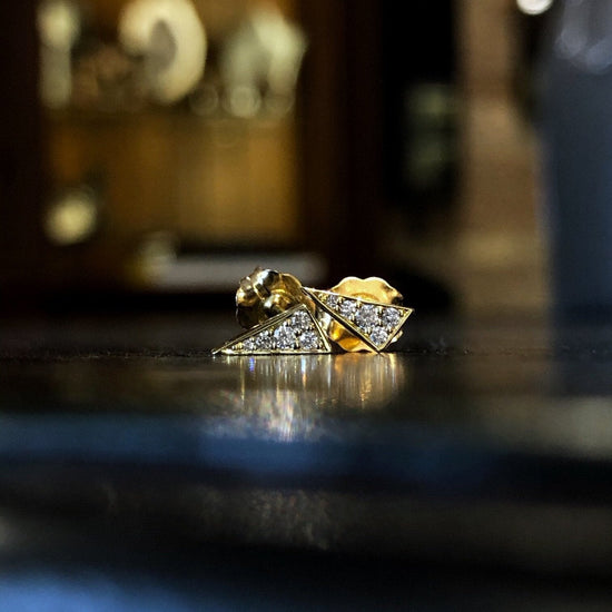 Photo of Naledi Collection Triangular Studs in a decorative scene, designed by , available at Plumb Gold & Plumb Silver
