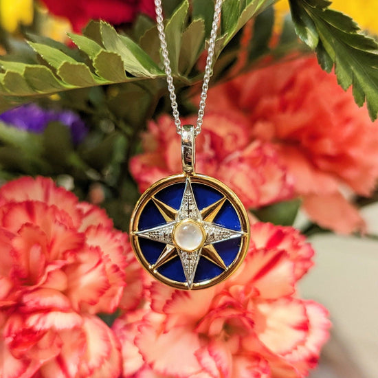 Photo of Navy Blue Gold Plate Celestial Necklace in a decorative scene, designed by , available at Plumb Gold & Plumb Silver