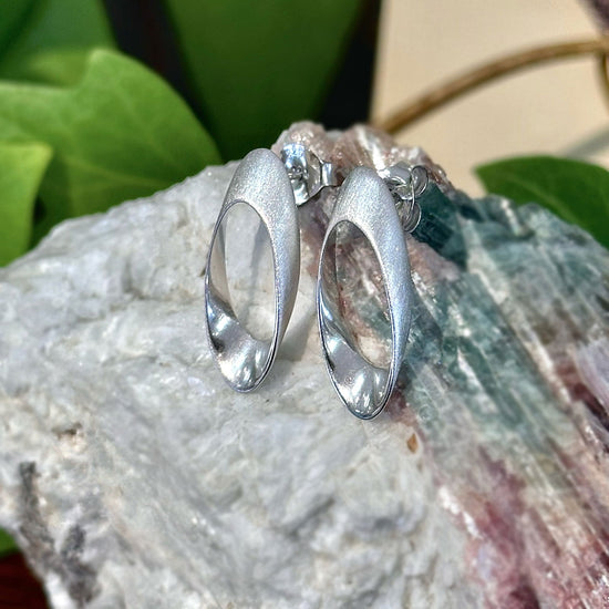 Photo of "Nova" Post Earring in a decorative scene, designed by -, available at Plumb Gold & Plumb Silver
